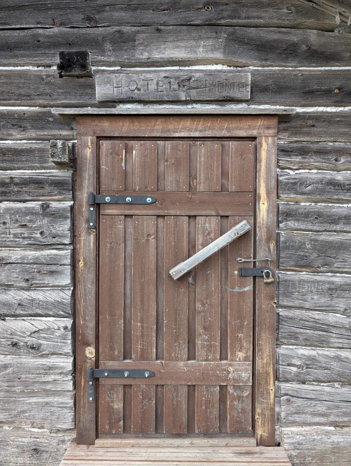 The classic "Hotelli Montel" wooden sign and the cabin door